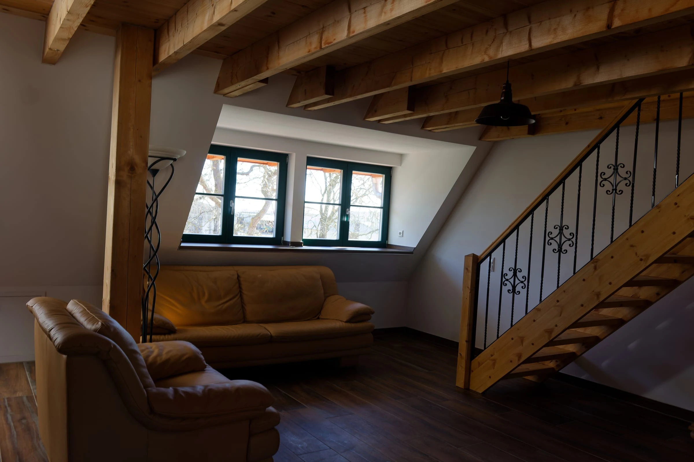 Wohnbereich von Ferienwohnung 4 mit Sofa und Holztreppe