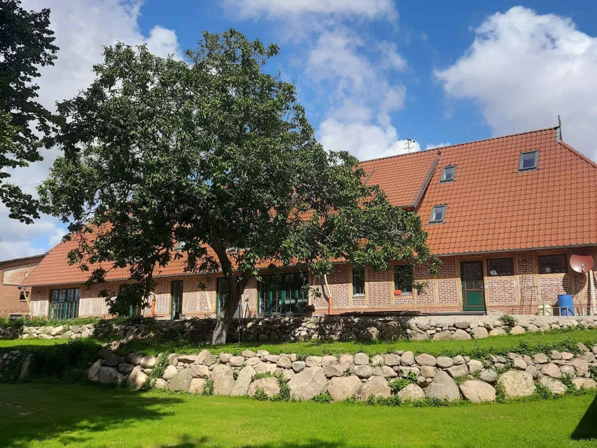 Gartenseite des Landhauses Ravensberg mit altem Baumbestand und Feldsteinmauern