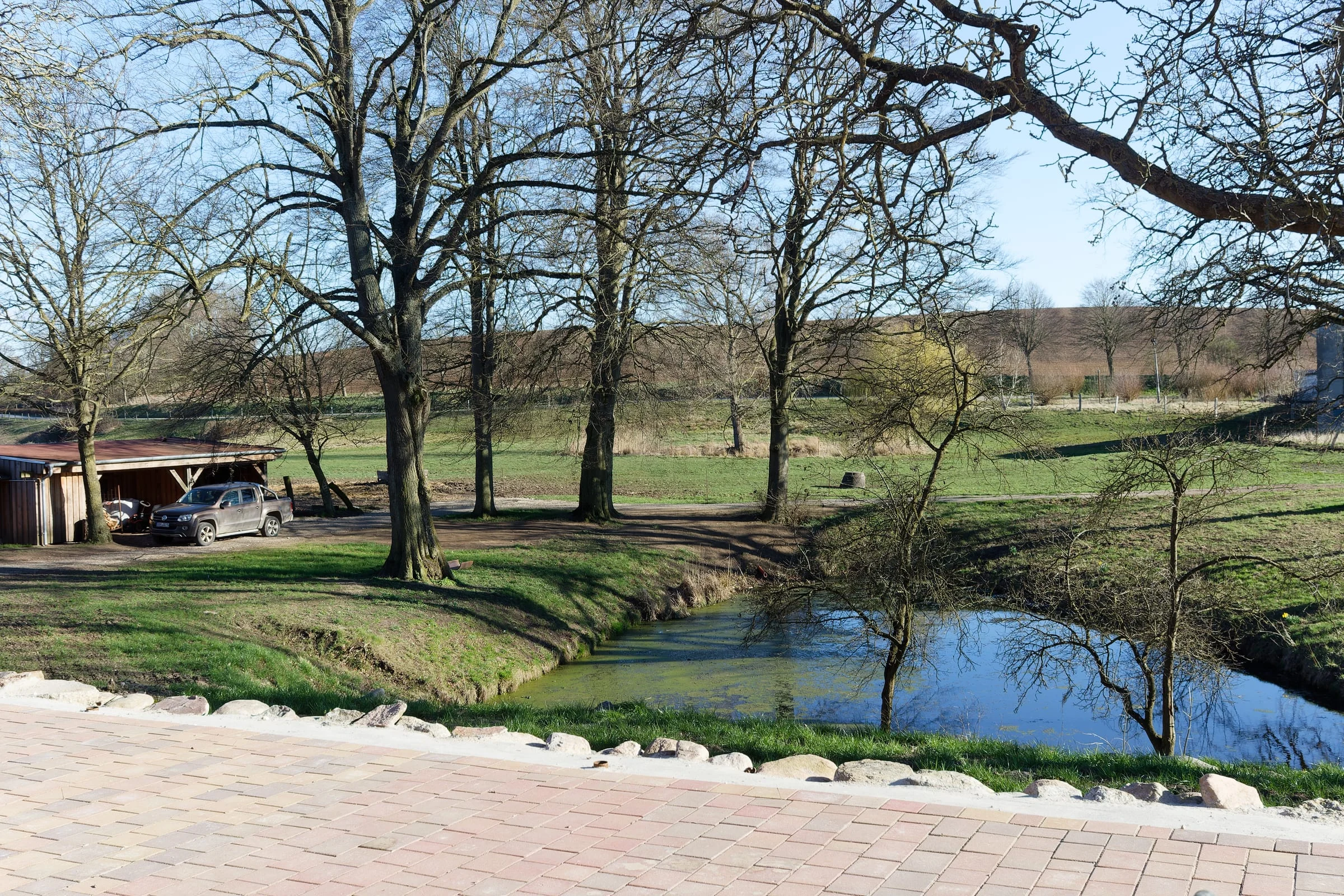 Blick von der Terrasse über den Teich und die Wiesen am Landhaus