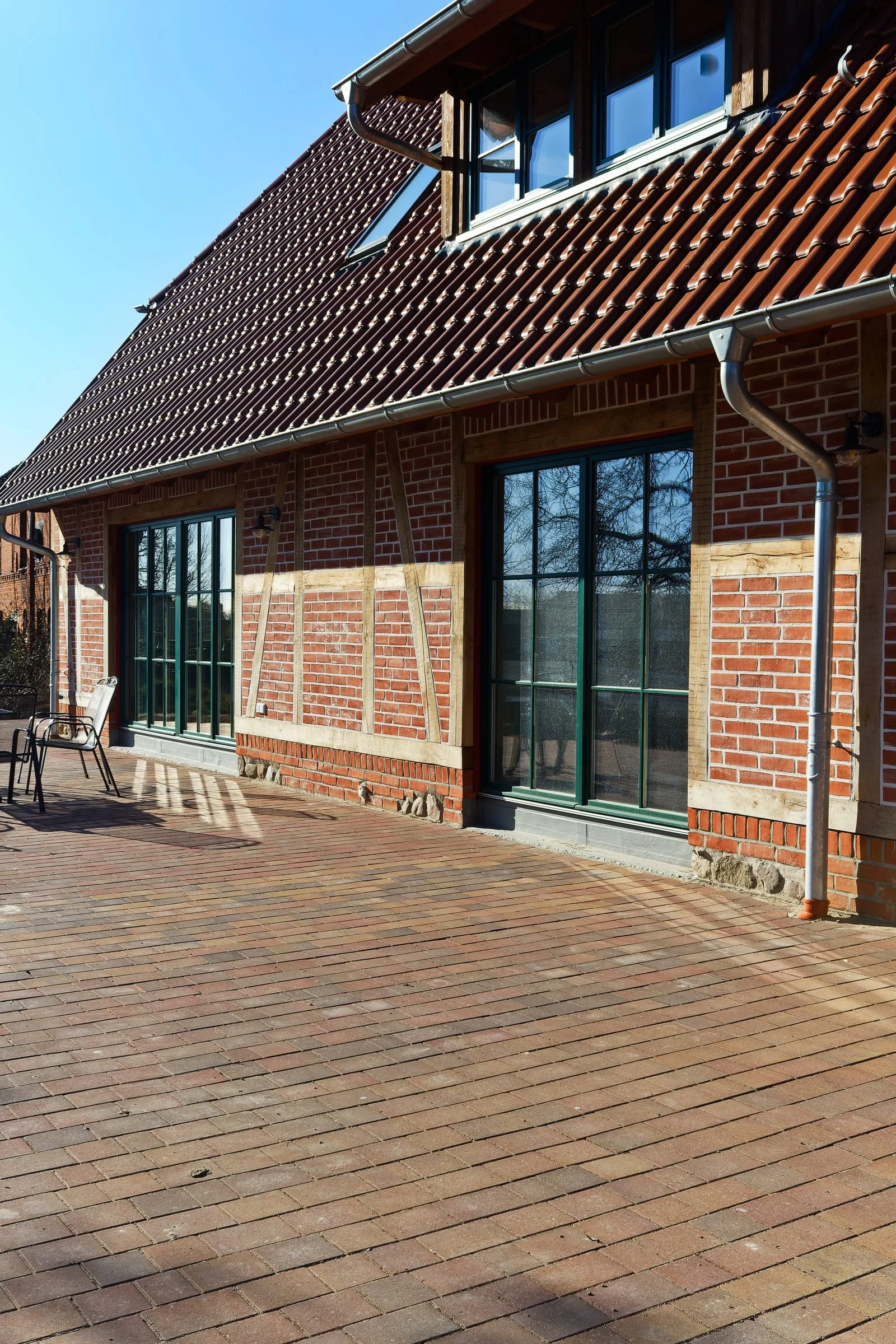 Fassade und Terrasse des Landhauses im Sonnenlicht